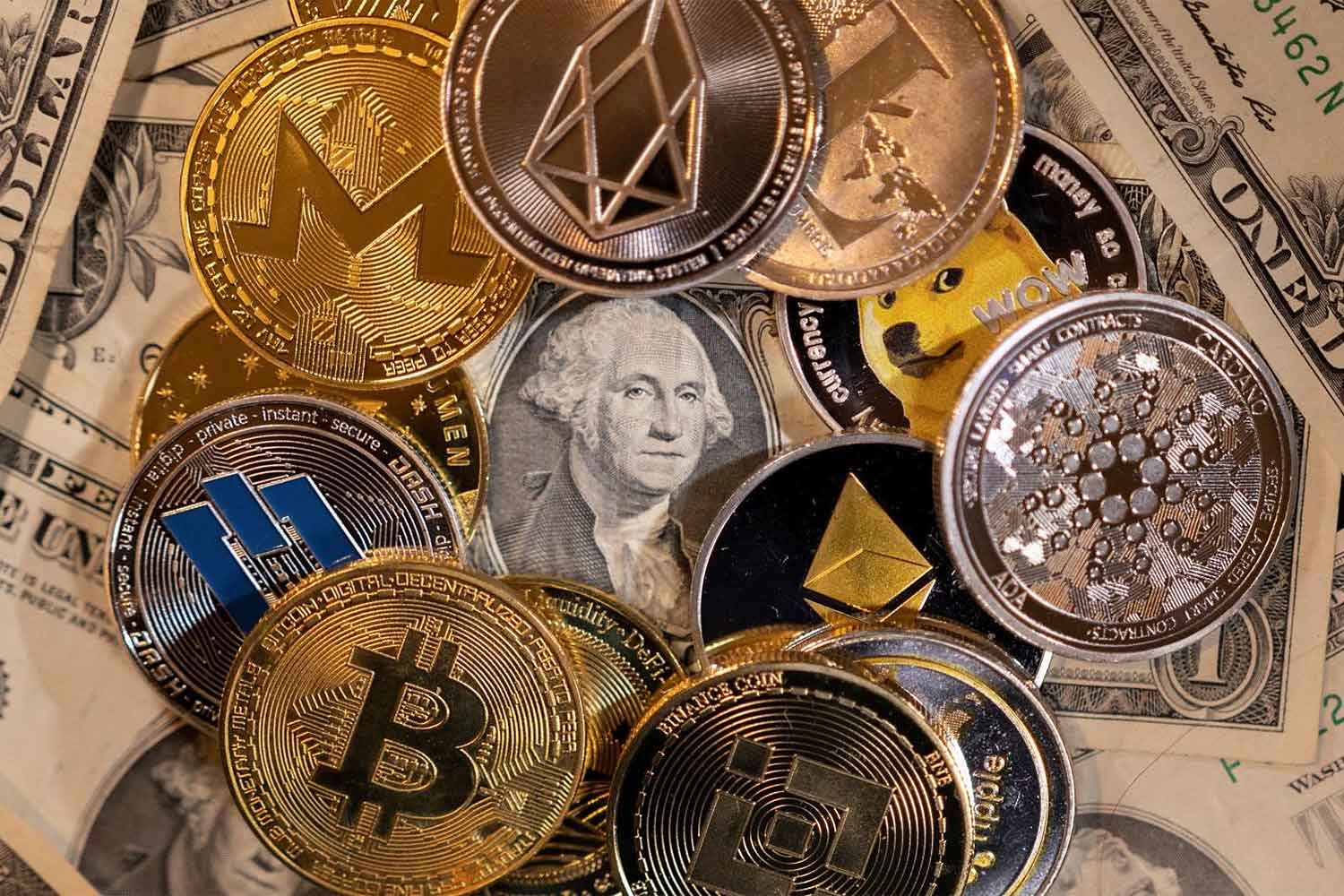 Representations of cryptocurrencies are placed on US banknotes in this illustration taken Nov 28, 2021. (Reuters photo)