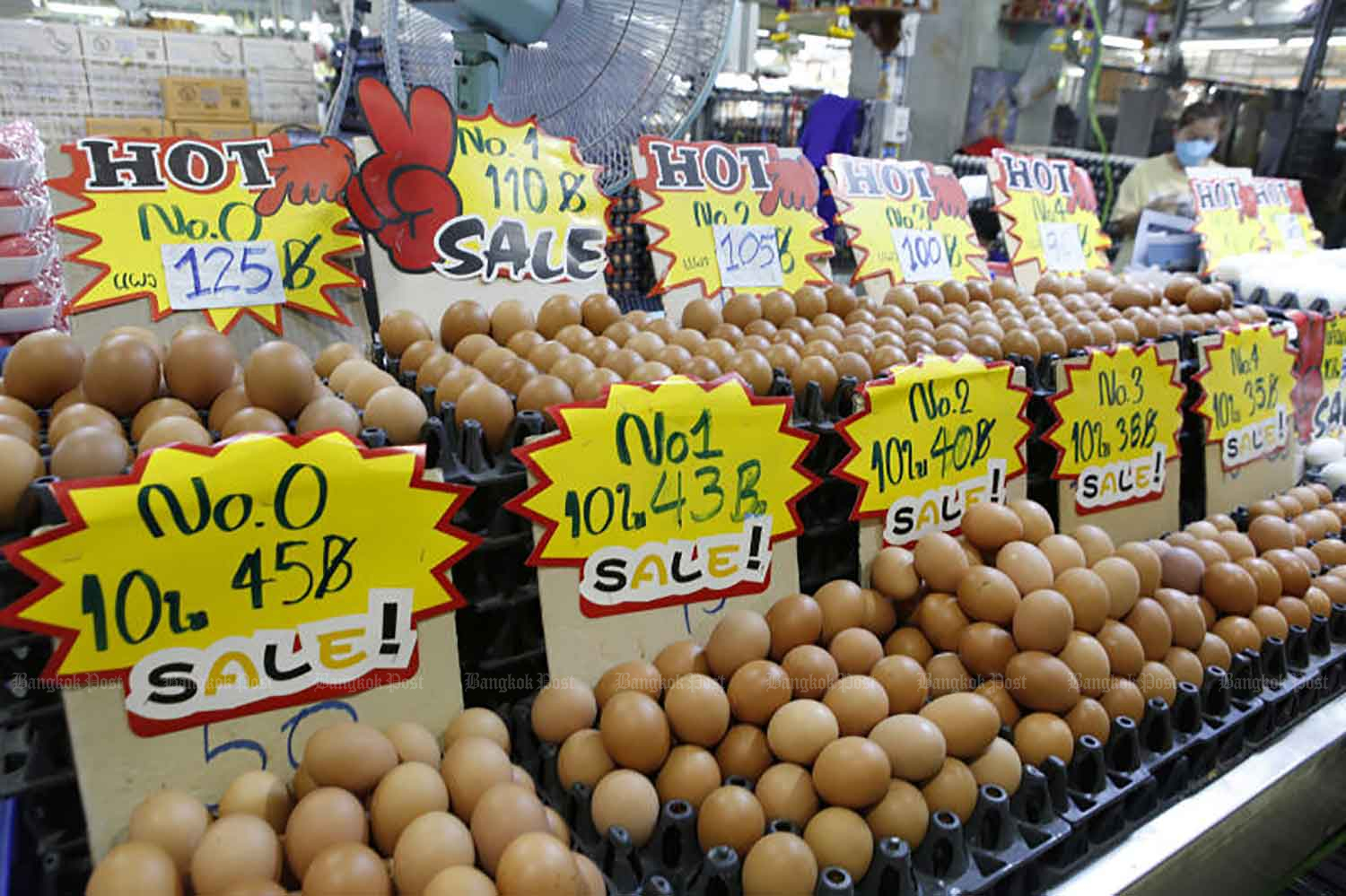 Eggs are displayed at Simummuang Market in Pathum Thani on Monday. Market vendors are maintaining the price of eggs at their current level, despite prices going up by 5-6 baht per tray of 30 elsewhere. The Layer Chickens Association said the increase is caused by high feed and veterinary drug costs. (Photo: Apichit Jinakul)