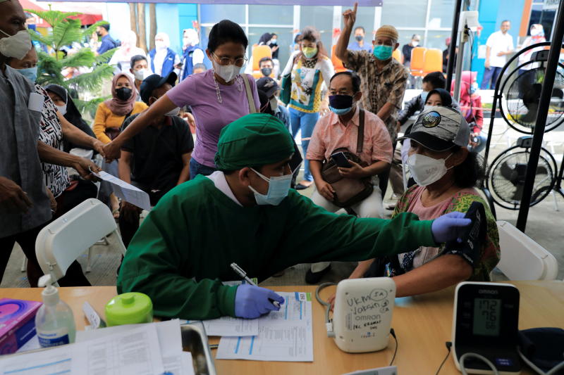 A medical worker performs a health screening on a woman who will receive a booster dose vaccine against the coronavirus disease, as the country starts the booster vaccination programme for the general public amid the rises of the Omicron variant in Jakarta, Indonesia, on Wednesday. (AFP photo) A medical worker performs a health screening on a woman who will receive a booster dose vaccine against the coronavirus disease, as the country starts the booster vaccination programme for the general public amid the rises of the Omicron variant in Jakarta, Indonesia, on Wednesday. (AFP photo)