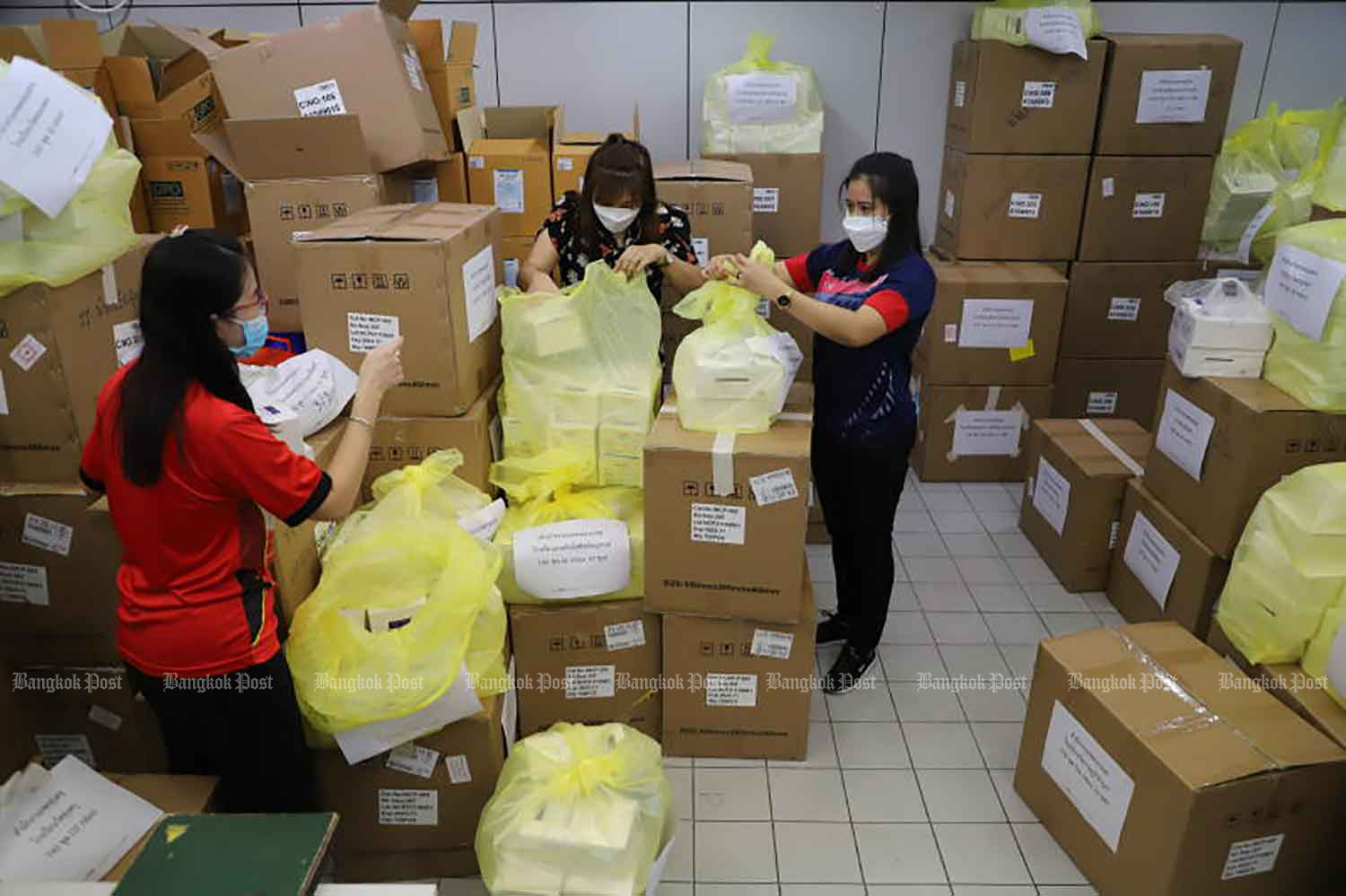 Staff at the Bangkok Metropolitan Administration's education office on Wednesday prepare to distribute antigen test kits to BMA-run schools to randomly test students for Covid-19. (Photo: Wichan Charoenkiatpakul)