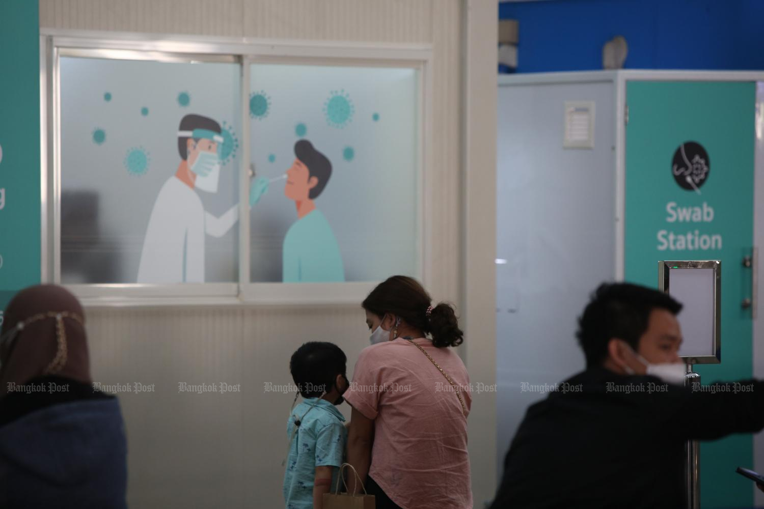 People wait outside a swab station located inside Suvarnabhumi airport. (Photo: Varuth Hirunyatheb)