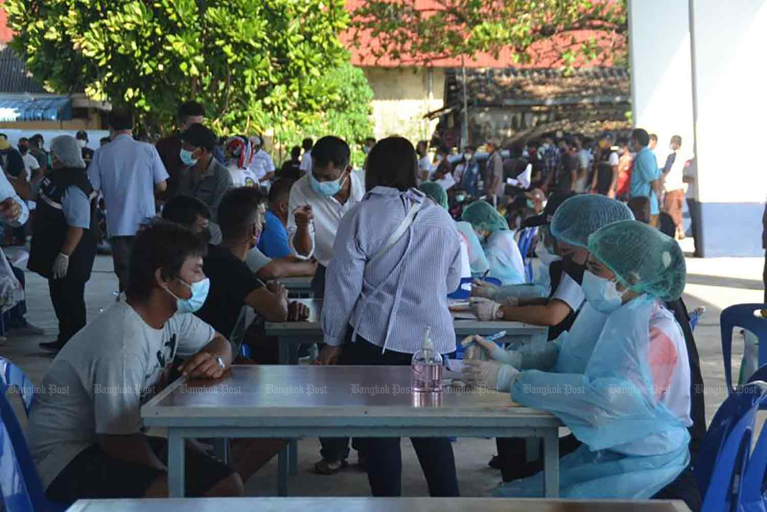 Health workers take down details of foreign crews of fishing boats, in preparation for giving them Covid-19 vaccinations, in Phuket province on Thursday. (Photo: Achadthaya Chuenniran)
็็