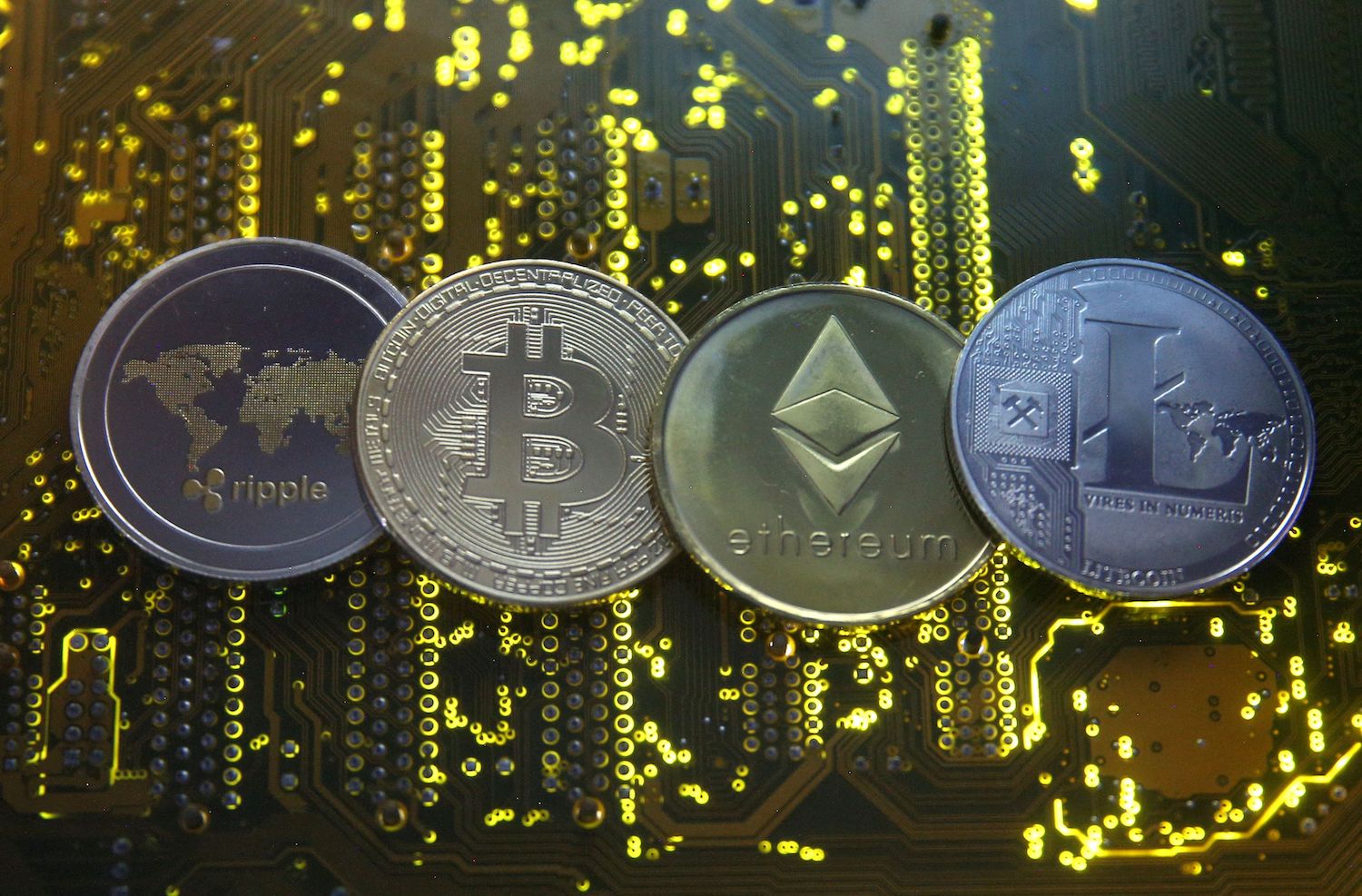 Representations of the Ripple, Bitcoin, Etherum and Litecoin virtual currencies are seen on motherboard. (Reuters File Photo) Representations of the Ripple, Bitcoin, Etherum and Litecoin virtual currencies are seen on motherboard. (Reuters File Photo)
