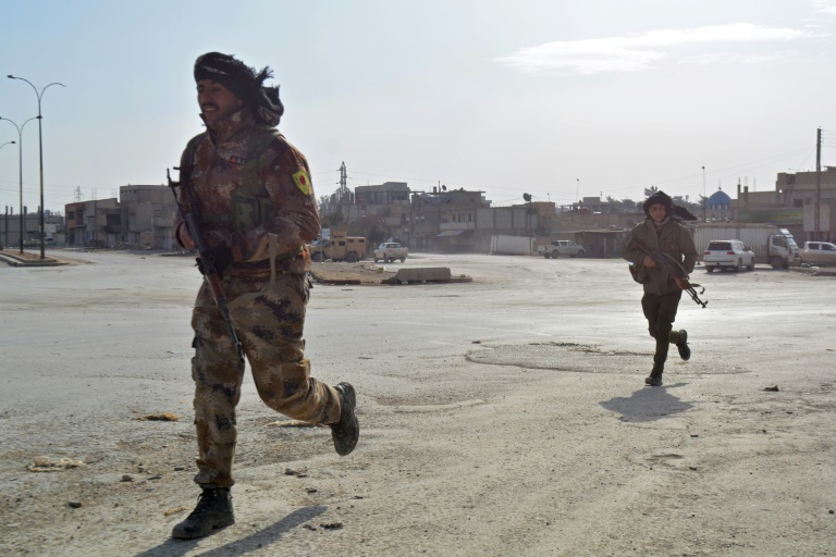 Syrian Democratic Forces (SDF) cross a street in the northern Syrian city of Hasakeh on January 23, 2022