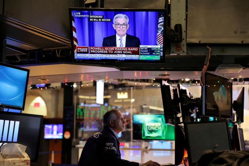 Federal Reserve Chair Jerome Powell is seen delivering remarks on a screen as a trader works on the trading floor at the New York Stock Exchange on Dec 15, 2021. (Reuters photo) Federal Reserve Chair Jerome Powell is seen delivering remarks on a screen as a trader works on the trading floor at the New York Stock Exchange on Dec 15, 2021. (Reuters photo)