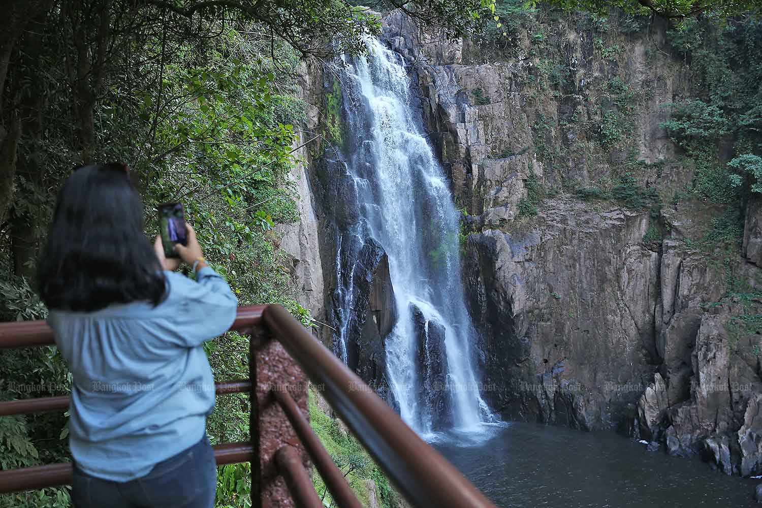 A tourist takes a photo of the Haeo Narok waterfall in Khao Yai National Park. The park is part of Dong Phayayen-Khao Yai Forest Complex, which together with Kaeng Krachan Forest Complex is at risk of having its World Heritage status downgraded. (Photos:  Varuth Hirunyatheb and Watcharawit Phudork)