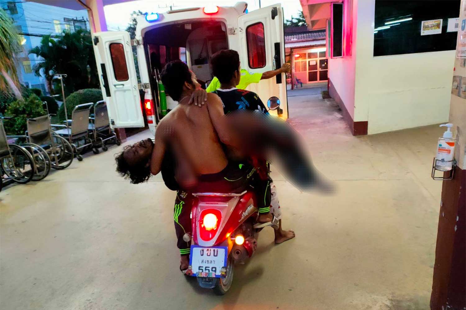 Badly injured Sutthisak Meansen, 44, is rushed to hospital by motorcycle after he stepped on buried bomb in Chana district, Songkhla, on Thursday evening. (Photo: Assawin Pakkawan)