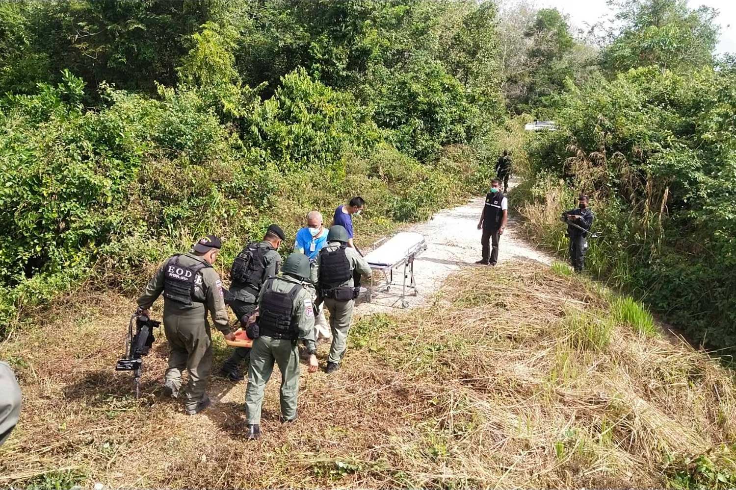 Explosive ordnance disposal officers carry the injured members of their squad away from the scene of the explosion, in Chana district, Songkhla, on Friday morning. (Photo supplied/ Assawin Pakkawan)