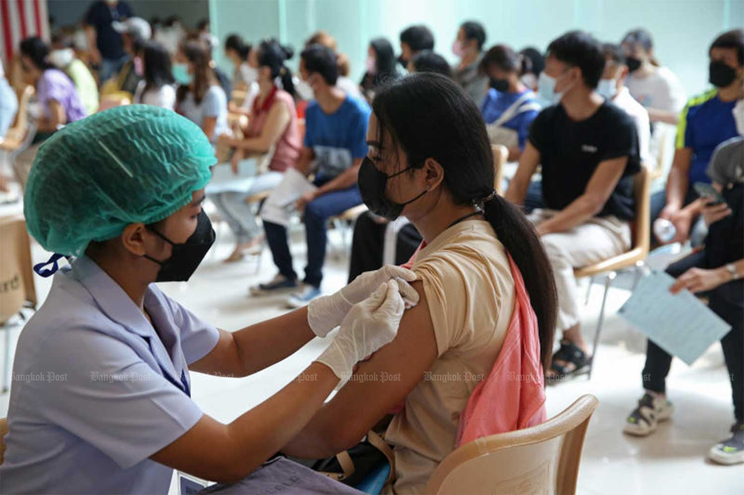 A health worker administers a booster shot of Covid-19 vaccine at Fashion Island shopping mall on Ramintha Road in Bangkok on Thursday. (Photo: Varuth Hirunyatheb)