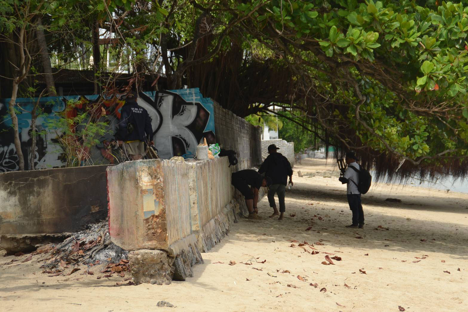 Police search Rawai Beach on Tuesday, near the villa where Jimi Sandhu was slain on Feb 4. Two discarded handguns were found in the sea. (Photo: Achadtaya Chuenniran)