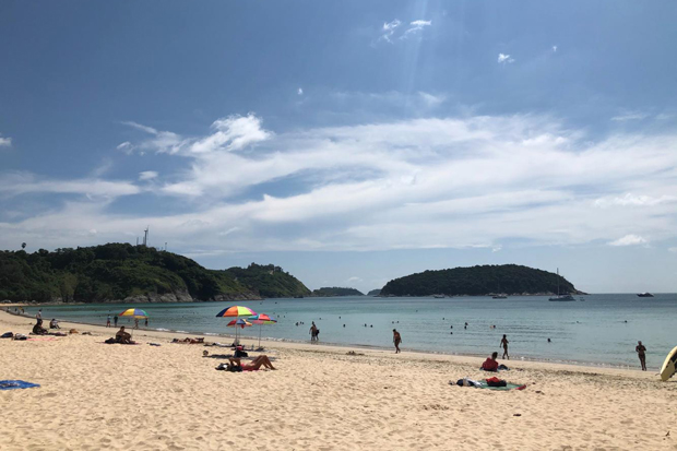 Zonniger dagen: Toeristen zonnebaden op Nai Han Beach.