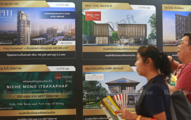 Potential buyers walk past advertisements at the House and Condo Fair in Sept 2019. (Photo: Somchai Poomlard)