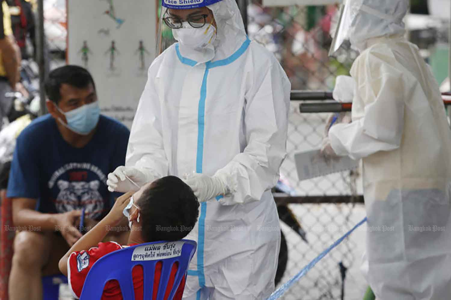 A boy gets swabbed for a Covid-19 test at Poonsap community in Bangkok's Sai Mai district on Monday. Out of the 183 people tested, four were infected. (Photo: Apichit Jinakul)