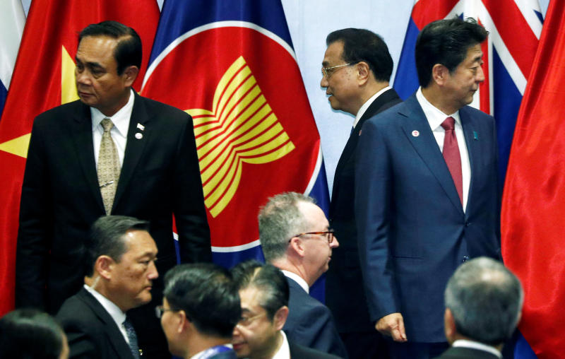 China's Premier Li Keqiang passes Japan's Prime Minister Shinzo Abe as they gather for a group photo with Asean leaders at the Regional Comprehensive Economic Partnership (RCEP) meeting in Singapore Nov 14, 2018. Thailand's Prime Minister Prayut Chan-o-cha looks on in the background. (File photo: Reuters)