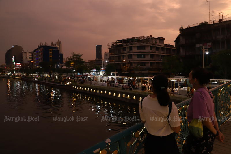 People enjoy time on a bridge crossing Phadung Krung Kasem canal in Bangkok on March 18, 2022. (Photo: Nutthawat Wicheanbut)