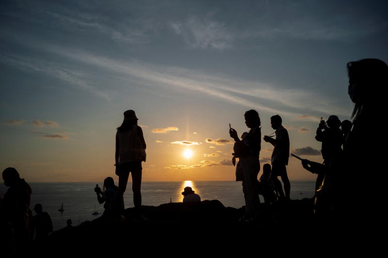 Locals and tourists watch a sunset from Phuket island's Phromthep Cape on Saturday.