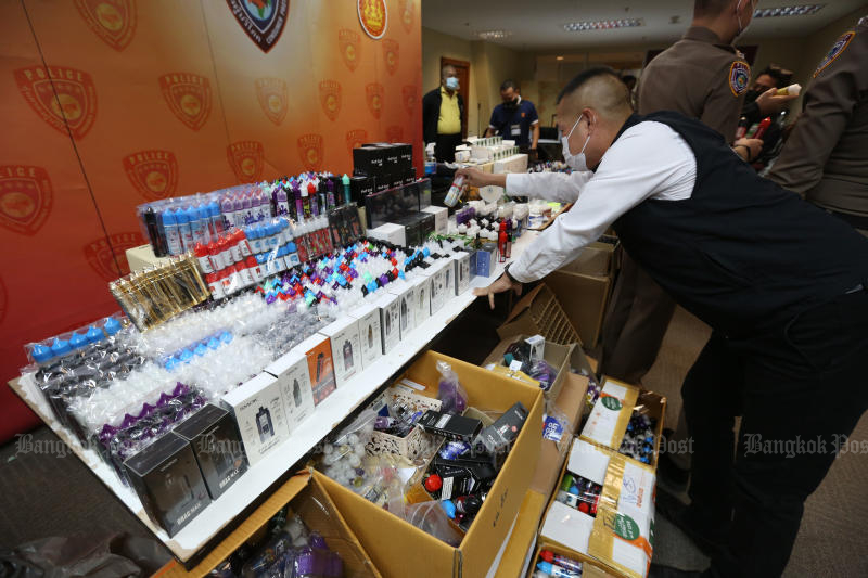 A staff puts e-cigarettes, their chemical flavourings and other related materials on display before a press briefing by the Consumer Protection Police Division on Jan 27, 2021. (Photo: Varuth Hirunyatheb)