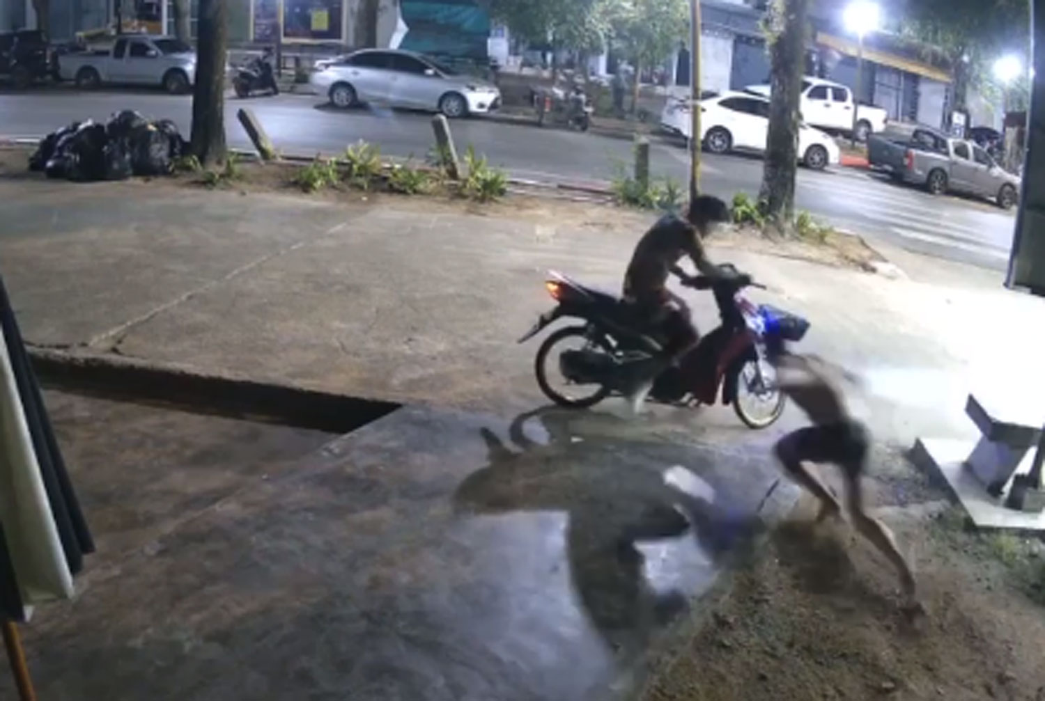 A tourist tries to retrieve his bag from a thief who is fleeing on a motorcycle at Ao Nang Beach in Krabi in the early hours of April 24. The thief, who turned out to be a former boxer, is caught. (Capture from a clip posed by Krabi TV Online)