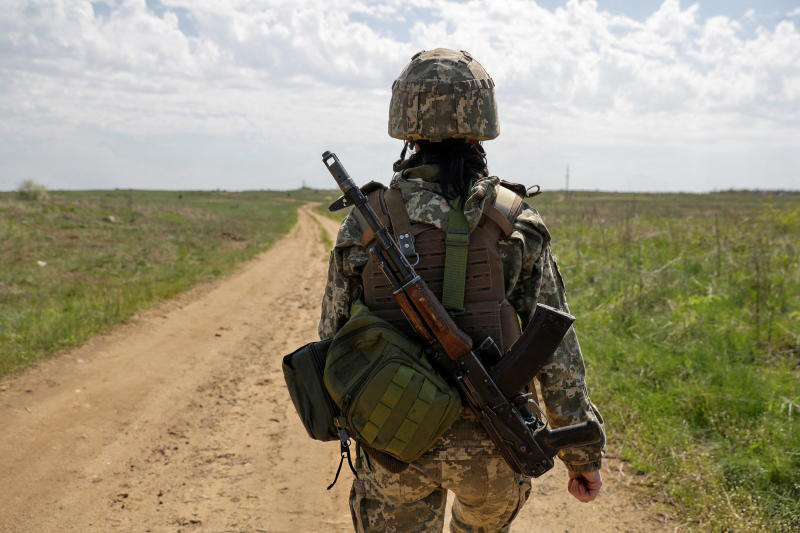 A Ukrainian servicewoman walks at a position, as Russia's attack continues in Luhansk Region on Tuesday. The Russia-Ukraine war is a factor affecting Thailand's economic growth this year. (Reuters photo)