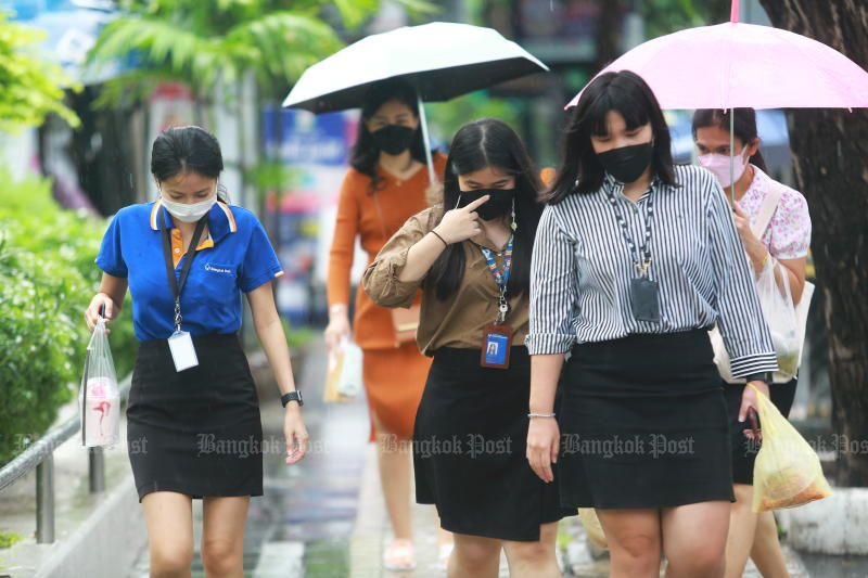 Office workers walk in the rain during lunch break on Bangkok’s Silom Road. (File photo: Bangkok Post)