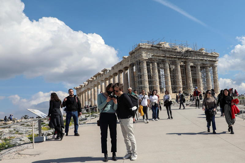 People visit the ancient Parthenon Temple atop the Acropolis hill archaeological site in Athens, Greece, on Feb 26, 2022. (Reuters photo)