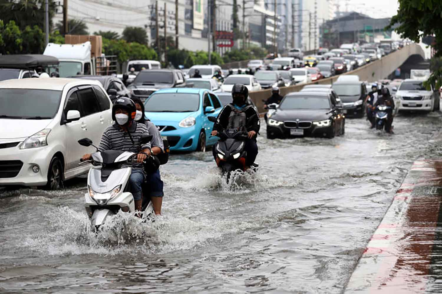 Motorists navigate heavy floods at the Ratchada-Lat Phrao intersection late Wednesday afternoon. Many parts of Bangkok were ravaged by flooding caused by morning and evening downpours. (Photo: Nutthawat Wicheanbut)