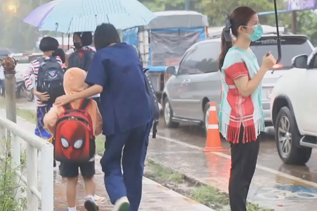 Umbrellas shield students from the rain as they go to school in Sangkhla Buri district of Kanchanaburi province on Friday. (Photo by Piyarat Chongcharoen)