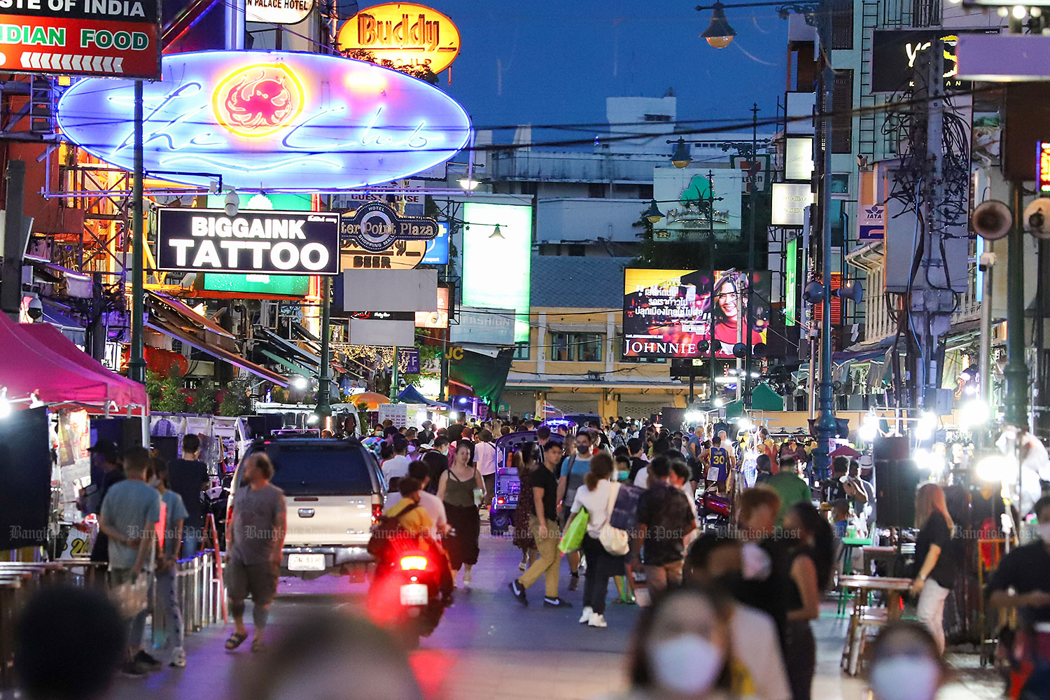 Light at the end of the tunnel: Neon lights illuminate Khao San Road after dusk as more pub-cum-restaurants and street food stalls ply their trade, luring crowds to the street. A boost in tourism is expected from June 1 with government allowing nightspots in Bangkok and another 30 provinces to resume business after being closed for over two years. (Photo: Pattarapong Chatpattarasil)