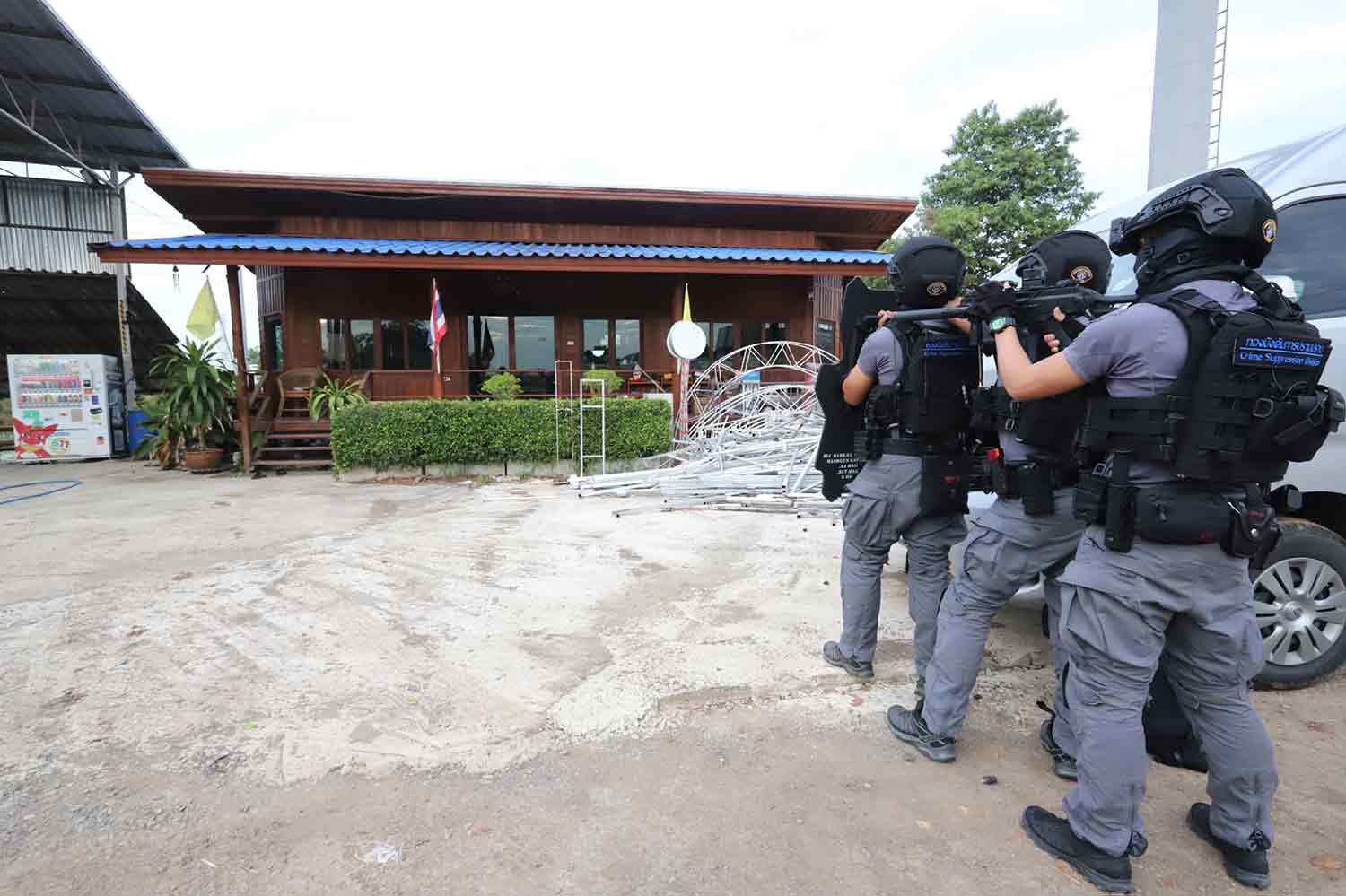 Crime Suppression Division police enter the premises of Ruanrua Ngoenthong Tractor Company in Pathum Thani's Sam Khok district on Tuesday morning. (Photo supplied)