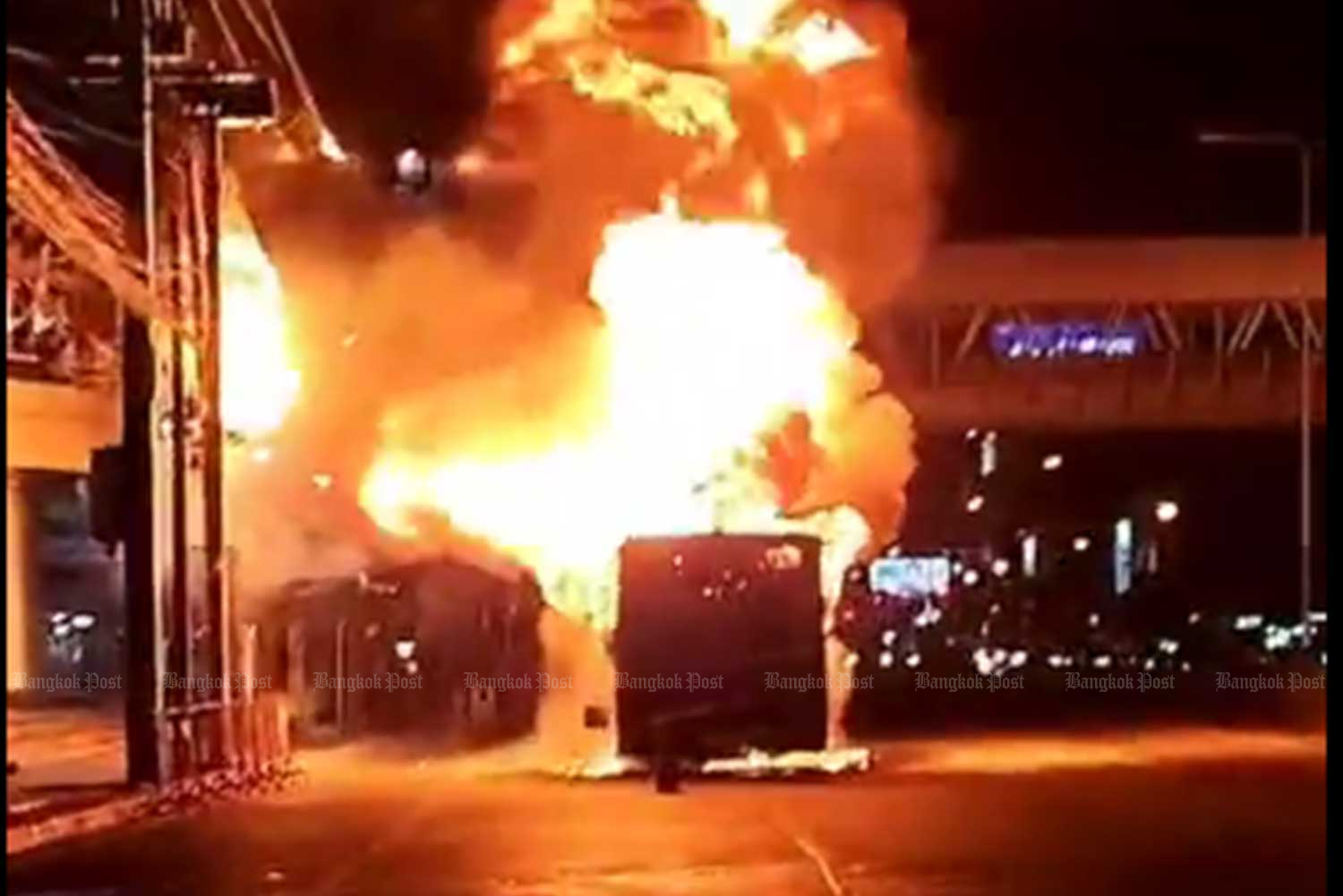 Flames engulf the No.552 bus in front of a shopping mall on Ngam Wong Wan Road in Nonthaburi on Mondaynight. (Capture from a clip by @fm91trafficpro twitter)