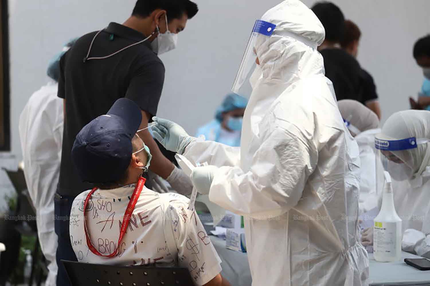 A medical worker administers the nasal swab component of an antigen rapid test in Pathumwan district, Bangkok, last month. (Photo: Nutthawat Wicheanbut)