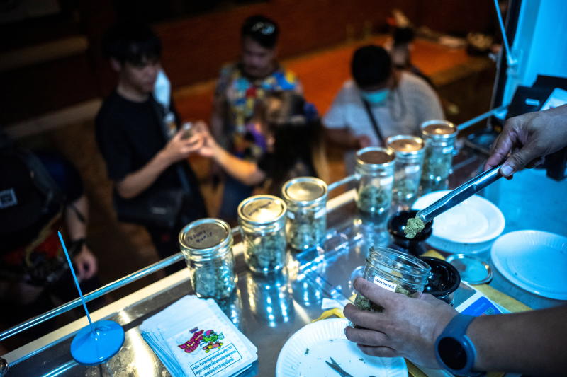 A staff member holds up a piece of cannabis as tourists queue up at the Happy Bud, a cannabis truck on Khaosan Road in Bangkok, Thailand, June 13, 2022. (Reuters photo)