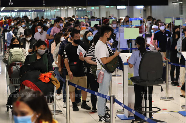 Passengers wait their turn to submit a QR code from Thailand Pass to public health officers at Suvarnabhumi airport, Samut Prakan province, on May 1, 2022. (Photo: Wichan Charoenkiatpakul)