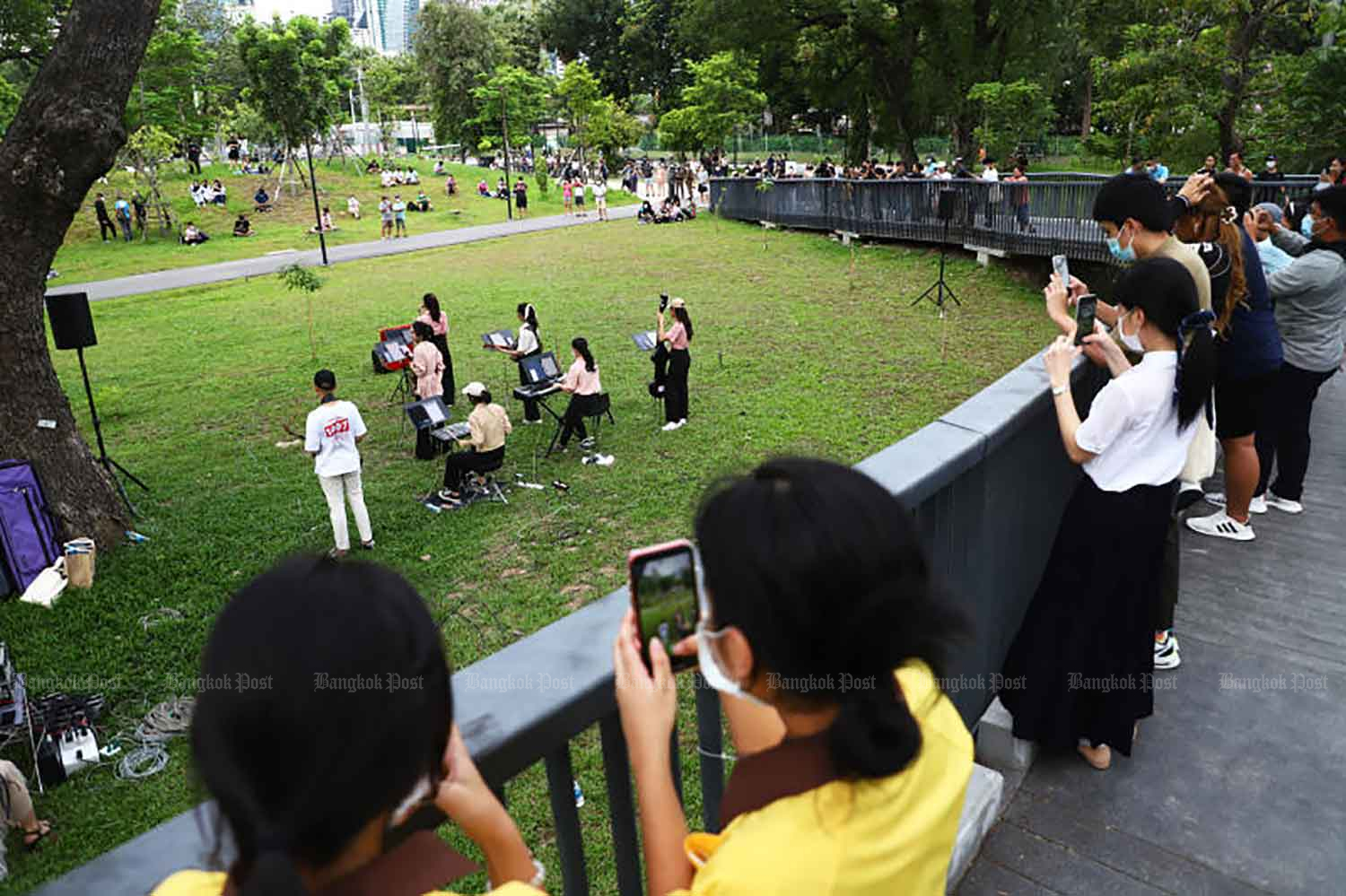 People wearing face masks watch a musical performance at Benjakitti Park in Bangkok early this month. (Photo: Nutthawat Wicheanbut)