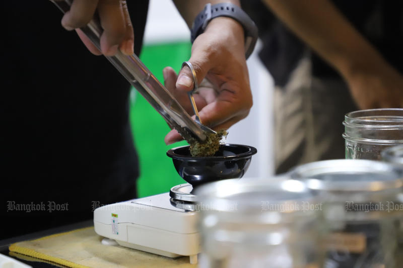 A mobile stall owner sells marijuana to people on Khao San Road on June 13, 2022. The drug, which is selling for 700 baht a gramme, is in demand following its recent removal from the illegal narcotics list. (Photo: Varuth Hirunyatheb)