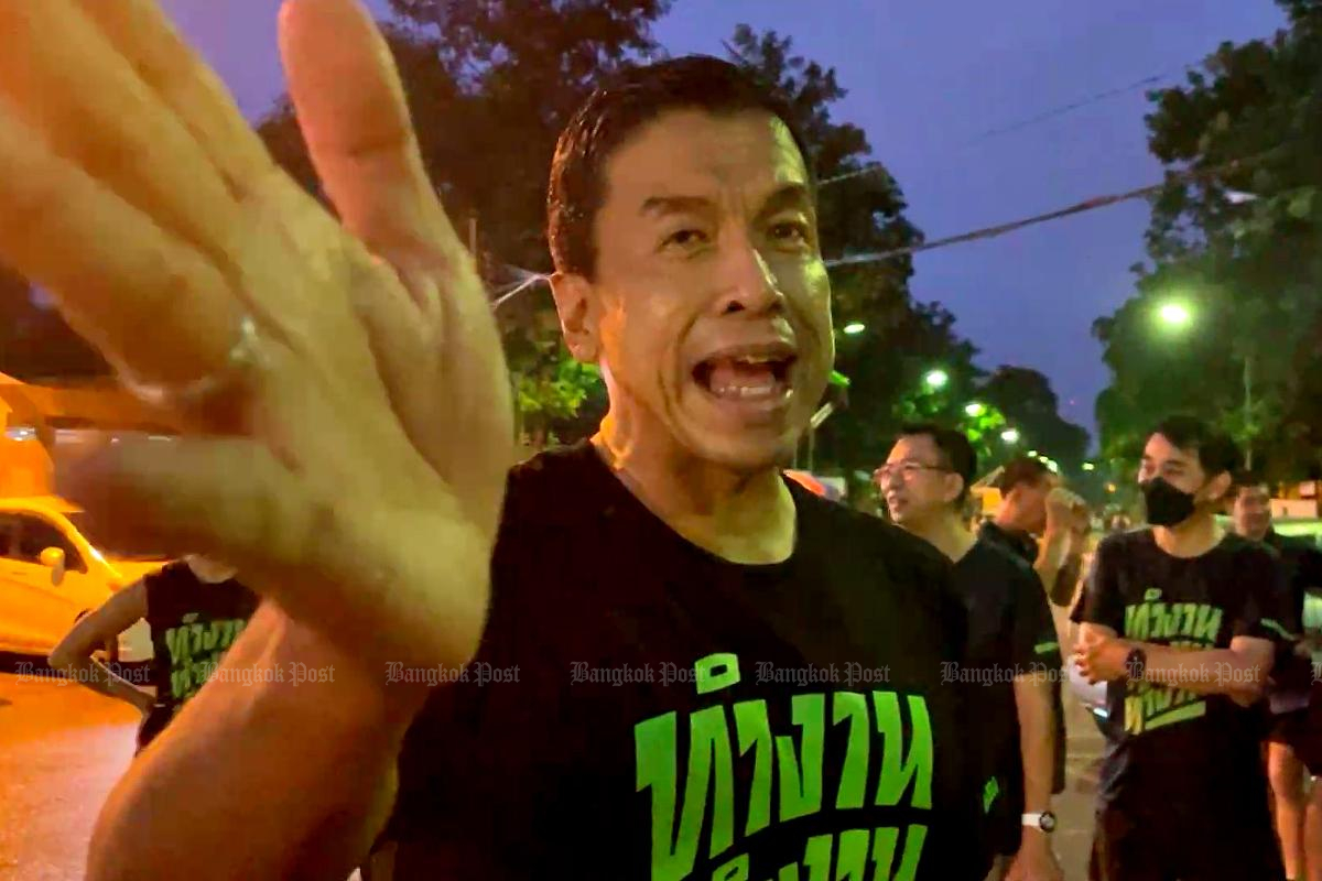 Bangkok governor Chadchart Sittipunt on Saturday livestreams from his phone before taking his morning run at Lumpini Park without a mask.