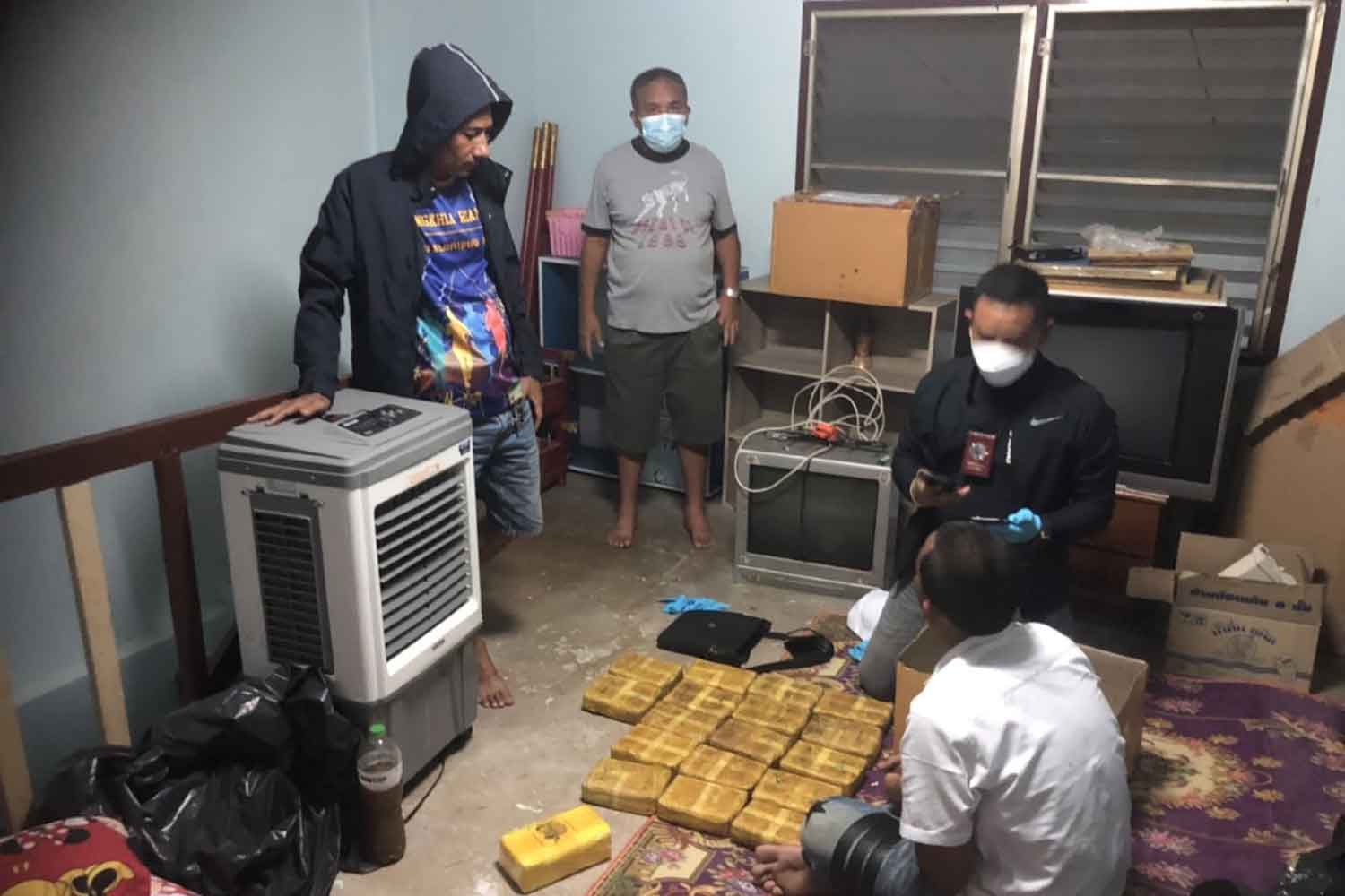 The 16-year-old boy, seated right, is arrested during a police search of a house in Songkhla's Hat Yai district on Sunday. A total of 112,000 methamphetamine pills were found in the room. (Photo: Assawin Pakkawan)