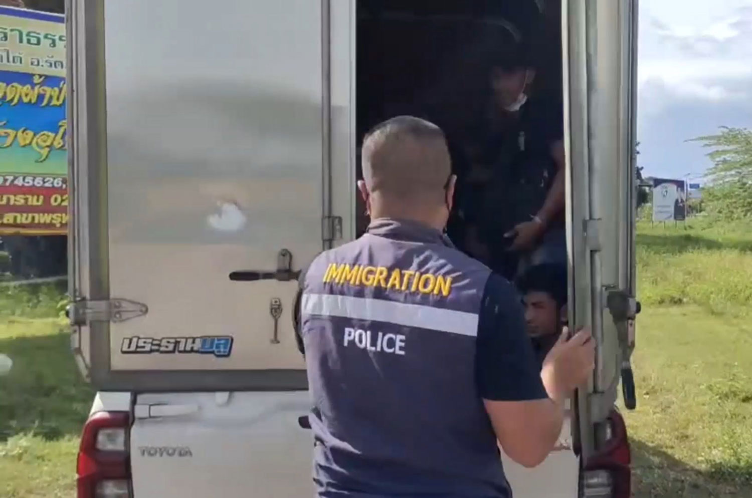 An immigration officer opens the door of a box pickup truck and finds many Myanmar nationals crammed inside at a road checkpoint in Rattaphum district, Songkhla. (Photo: Assawin Pakkawan)