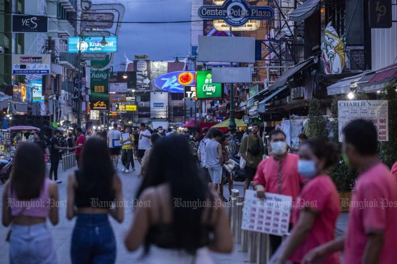 Pedestrians on Khao San Road on Saturday. Foreign tourist arrivals into Thailand are set to beat official forecasts with the lifting of pandemic-era restrictions. (Bloomberg photo)