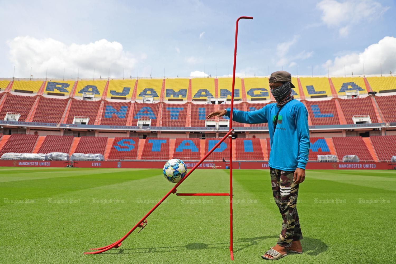 A worker tests the pitch at Rajamangala National Stadium on Tuesday. Photo by Varuth Hirunyatheb