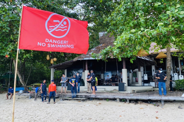 A red flag stands on a beach where two tourists went swimming on Ko Chang in Trat on Sunday. (Photo: Jakkrit Waewkraihong)