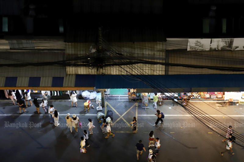 Shoppers walk round the famous Chatuchak weekend market at night after the Bangkok Metropolitan Administration eased Covid-19 restrictions, on Sunday. (Photo: Nutthawat Wicheanbut)