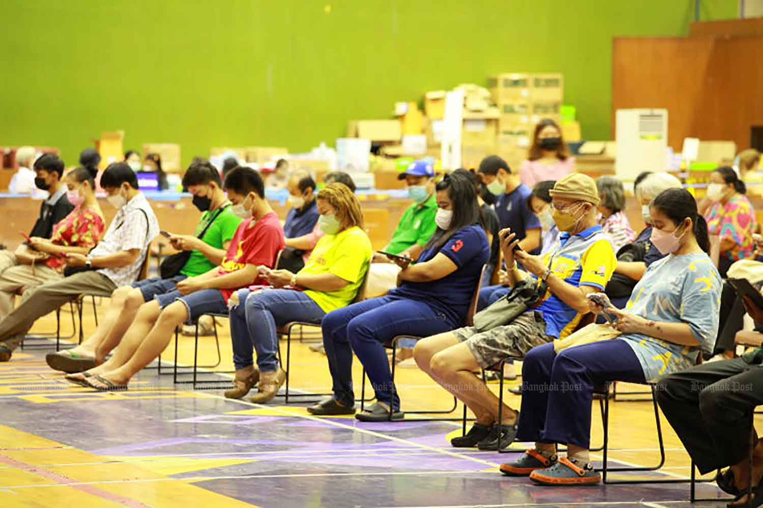 People arrive for Covid-19 vaccination at the Bangkok Youth Centre in Din Daeng district on Thursday. (Photo: Apichart Jinakul)