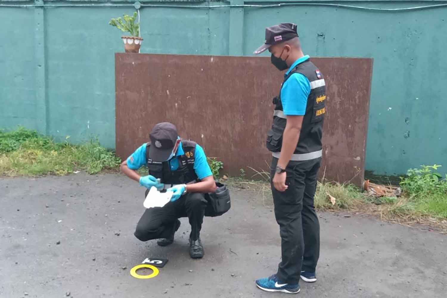 Forensic police note details at the scene of the fatal shooting in front of a pub in Phuket's Muang district early on Monday. (Photo: Achadthaya Chuenniran)