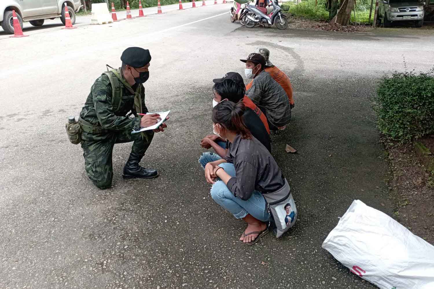 An army officer takes information from Myanmar nationals who had illegally crossed the border into Thailand at Ban Tha Khanun in Thong Pha Phum district, Kanchanaburi, on Sunday. (Photo: Piyarat Chongcharoen)