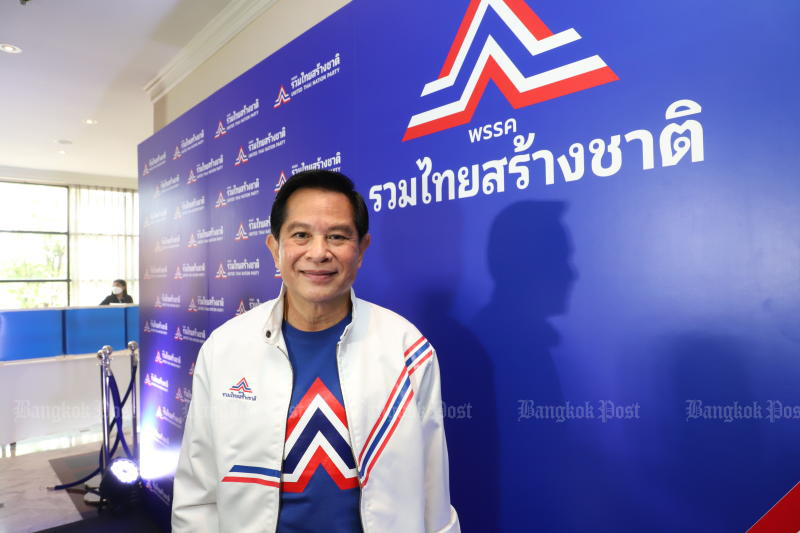 New Ruam Thai Sang Chart Party leader Pirapan Salirathavibhanga, who is an advisor to the prime minister, poses with the backdrop of the party logo on Wednesday. (Photo: Pattarapong Chartpattarasill)