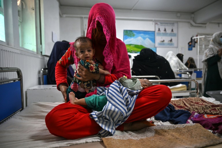 Breshna sits on a hospital bed with her four-month-old twins Subhania and Subhan in the malnutrition ward at a hospital run by Doctors Without Borders (MSF), in Lashkar Gah. Breshna sits on a hospital bed with her four-month-old twins Subhania and Subhan in the malnutrition ward at a hospital run by Doctors Without Borders (MSF), in Lashkar Gah.