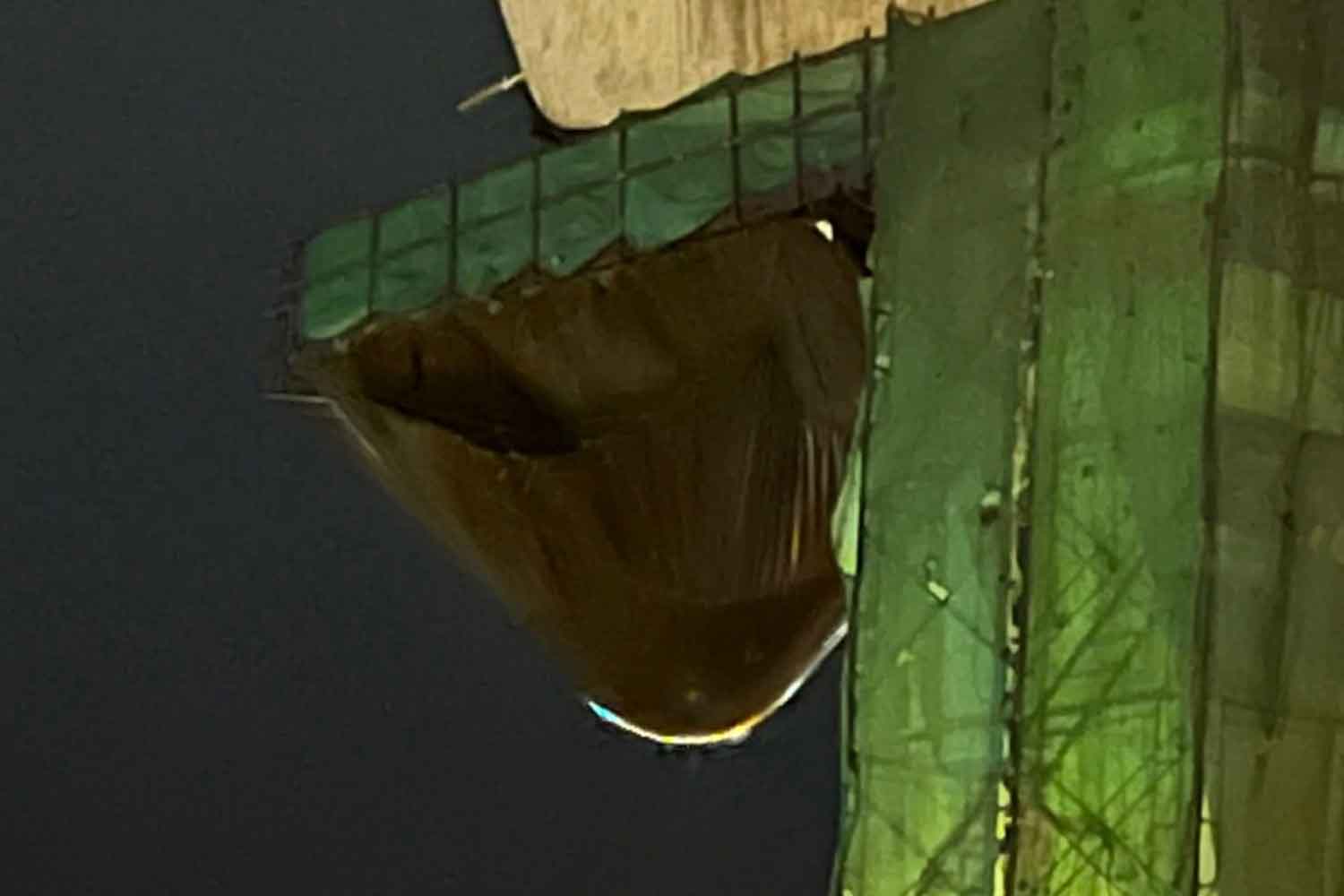 A water-logged sheet hangs from an elevated road under construction above Rama II Road in Bang Khun Thian district, Bangkok, on Thursday night. (Photo: Facebook page of Nitiphan Wongraksa)