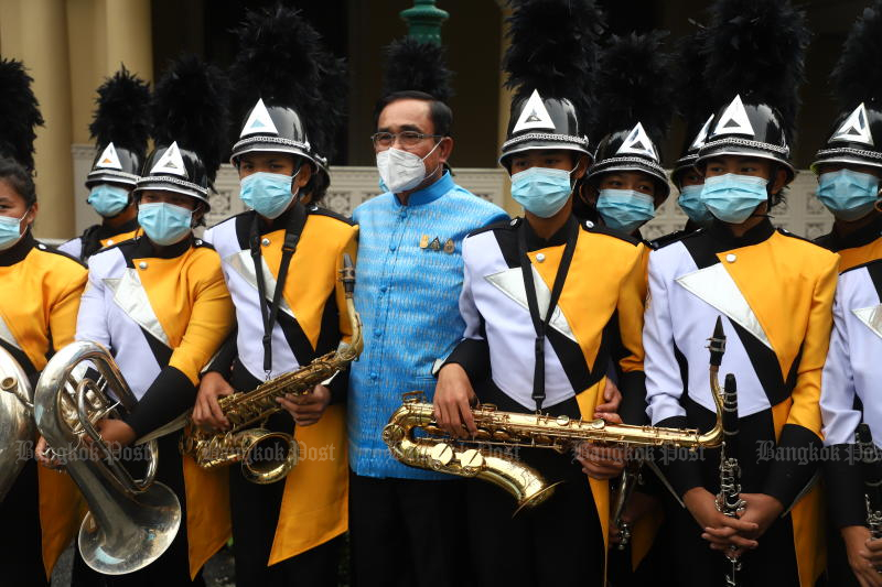 Prime Minister Prayut Chan-o-cha poses for pictures with a marching band at Government House on Aug 9. (Photo: Nutthawat Wicheanbut)