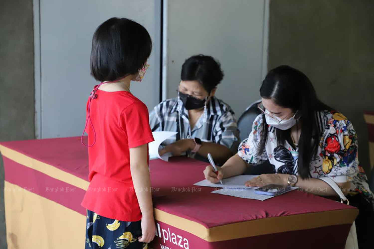 A girl registers for Covid-19 vaccination at a shopping mall in Nonthaburi province on Aug 4. (Photo: Pattarapong Chatpattarasill).